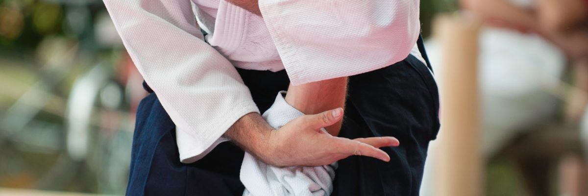 Aikido master brings an opponent down