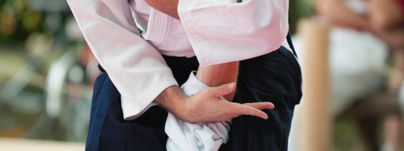 Aikido master brings an opponent down